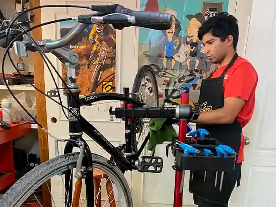 Mecánico de Traildog trabajando en una bicicleta en el taller